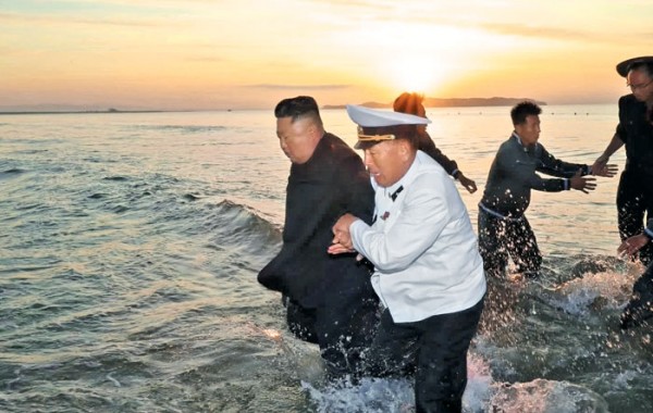 김정은 북한 국무위원장이 지난 24일 인민복 차림으로 바다에 들어가 참모들과 함께 